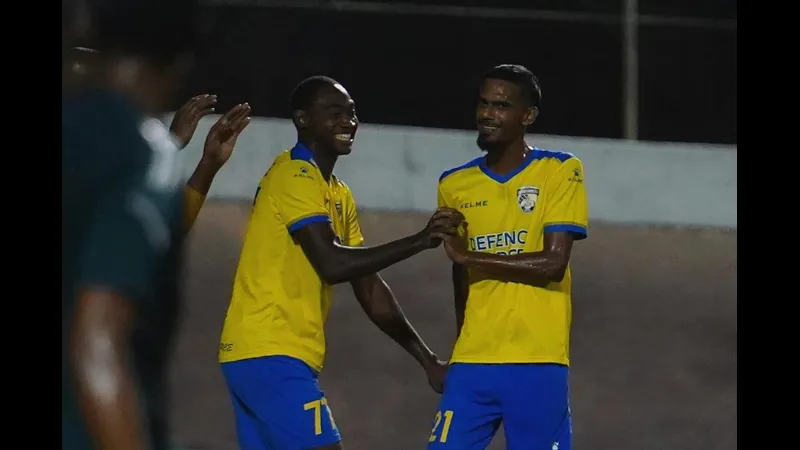 Cầu thủ của Defence Force đang kiểm soát bóng trước sự áp đảo từ Prisin Service Cầu thủ của Defence Force đang kiểm soát bóng trước sự áp đảo từ Prisin Service