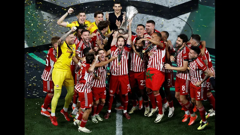 Cầu thủ Olympiakos chạy nhanh qua phòng ngự của Bayer Leverkusen Cầu thủ Olympiakos chạy nhanh qua phòng ngự của Bayer Leverkusen